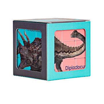 Side-on view of the Dinosaur Puzzle Cube in its packaging, which has windows in it to show the completed sides of the Triceratops and Diplodocus.